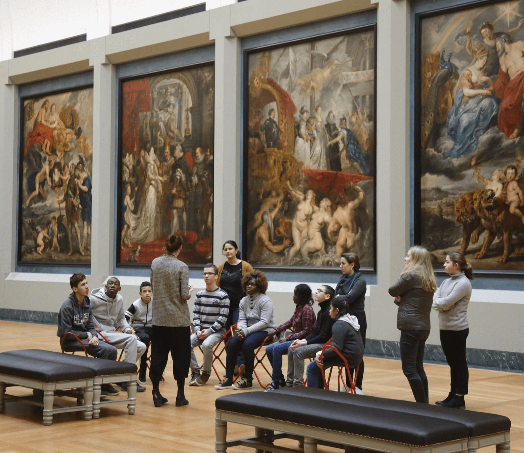 Louvre inspirational picture of an art teacher showing a group of people a work of art inside Louvre museum